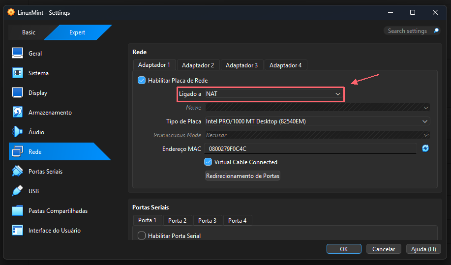 Configurações de Rede do VirtualBox. O contorno e a seta corais destacam o campo Ligado a, que mostra NAT nesta captura.