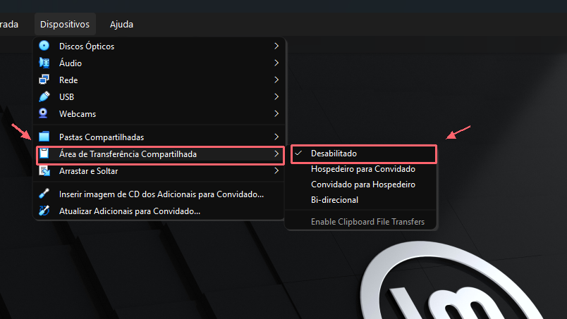 Menu Dispositivos aberto no VirtualBox. Contornos e setas corais destacam Área de Transferência Compartilhada e a opção Desabilitado marcada nesta captura.
